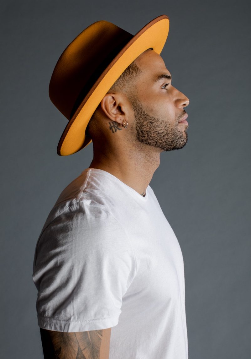 Zion wears hat Magill Fedora and t-shirt Frame Denim.
