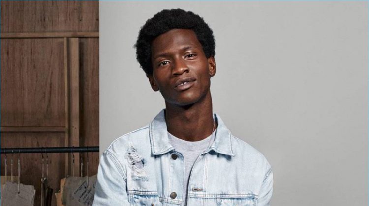 Connecting with H&M, Adonis Bosso wears a denim jacket, sweatshirt, and white skinny jeans.