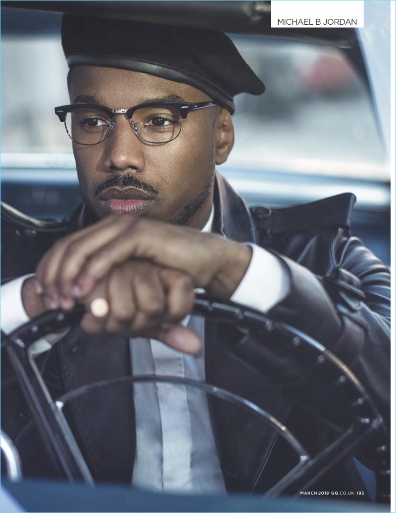 Going for a ride, Michael B. Jordan wears a leather Burberry coat. A Dior Homme shirt, Lock & Co. beret, and Ray-Ban glasses complete his look.