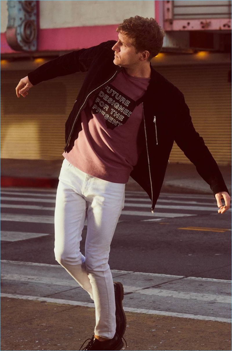 Dancer Nathan Mitchell rocks a biker jacket, sweatshirt, and white skinny jeans by H&M.