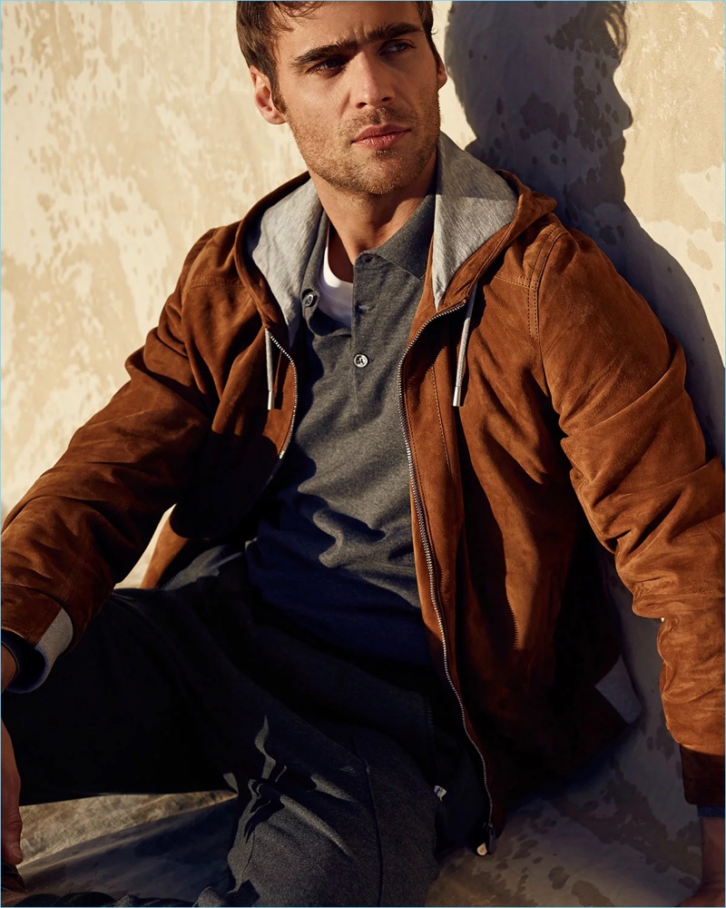 Sporting Brunello Cucinelli, George Alsford wears a suede hoodie, long-sleeve polo sweater, t-shirt, and sweatpants.