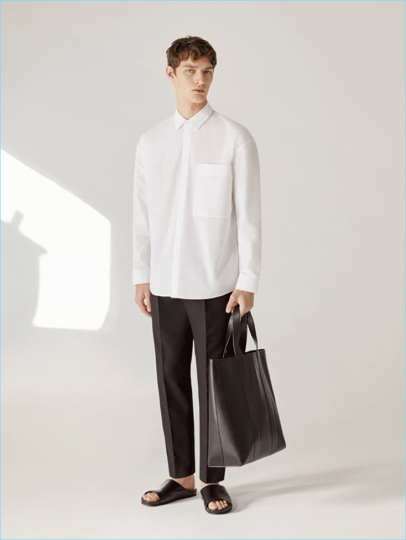 Embracing black and white, Otto Lotz wears a COS cotton shirt and slim-fit trousers with pleats. He also carries the label's structured leather tote bag.