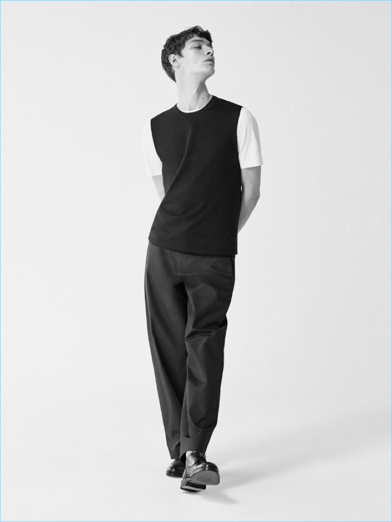 A sleek vision, Otto Lotz dons a COS round-neck t-shirt, CL Shrimpy knit crew neck, relaxed wide-leg cotton trousers, and matte-leather derby shoes.