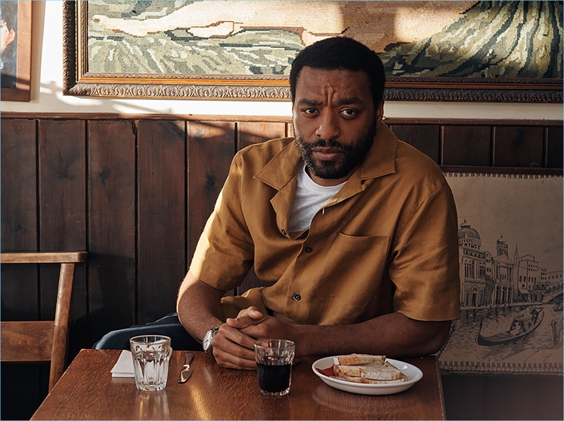 Starring in a photo shoot, Chiwetel Ejiofor wears an IWC Schaffhausen watch, Margaret Howell linen shirt, Sandro t-shirt, and Brunello Cucinelli trousers.