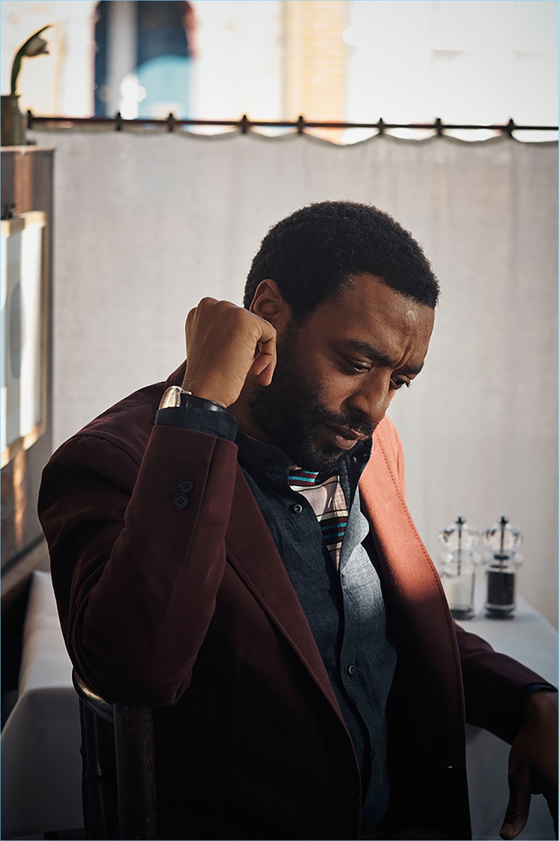 Actor Chiwetel Ejiofor sports an IWC Schaffhausen watch, P. Johnson jacket, Brunello Cucinelli linen shirt, and Prada sweater.