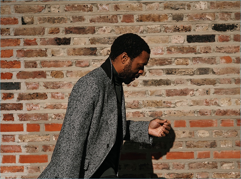 Delivering a side profile, Chiwetel Ejiofor wears a Salle Privée overcoat with an Ermenegildo Zegna sweater.