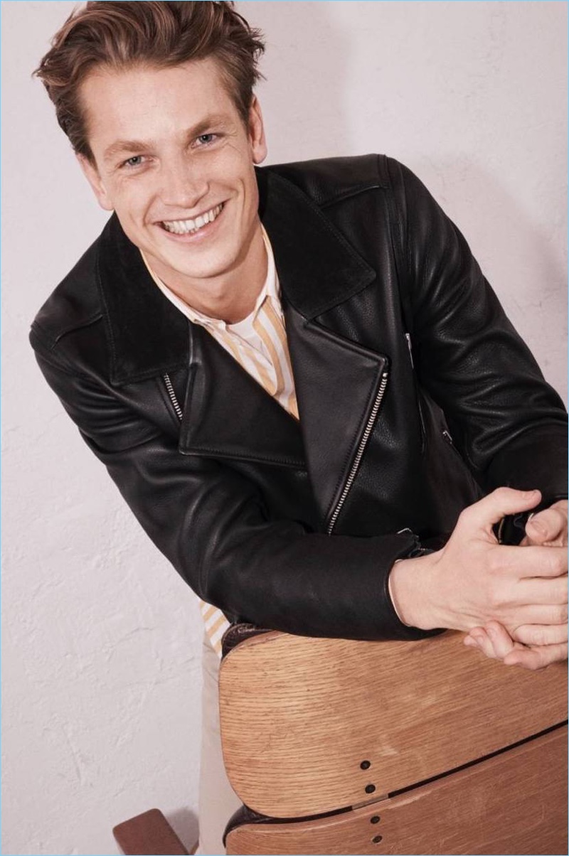 Smiling for the camera, Hugo Sauzay wears a yellow striped shirt with a H&M Edition leather biker jacket.