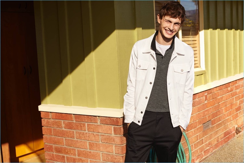 All smiles, Luc Defont-Saviard wears a H&M white denim jacket with a polo, t-shirt, and slim-fit chinos.