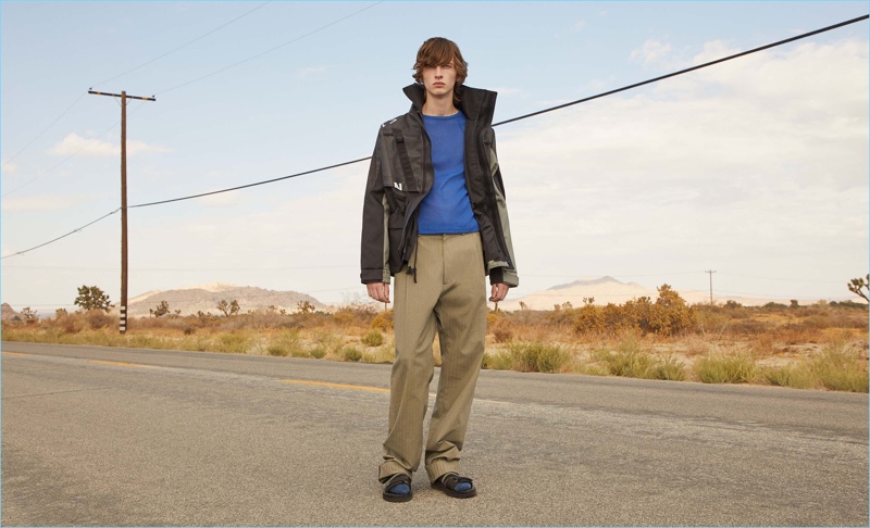 Hitting the road, Benno Bulang wears a X Helly Hansen contrast-panel technical parka, ribbed long-sleeve t-shirt, and trousers by GmbH. Making a casual statement, he also rocks Maison Margiela's multi-strap leather sandals.