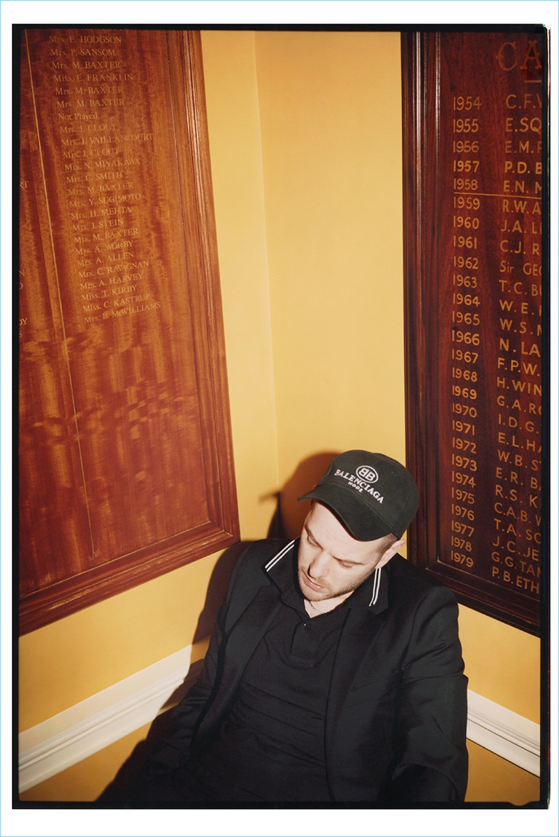 Embracing the logo trend, Mike Skinner wears a Balenciaga cap with a Prada suit jacket, Neil Barrett trousers, and a Stone Island polo shirt.