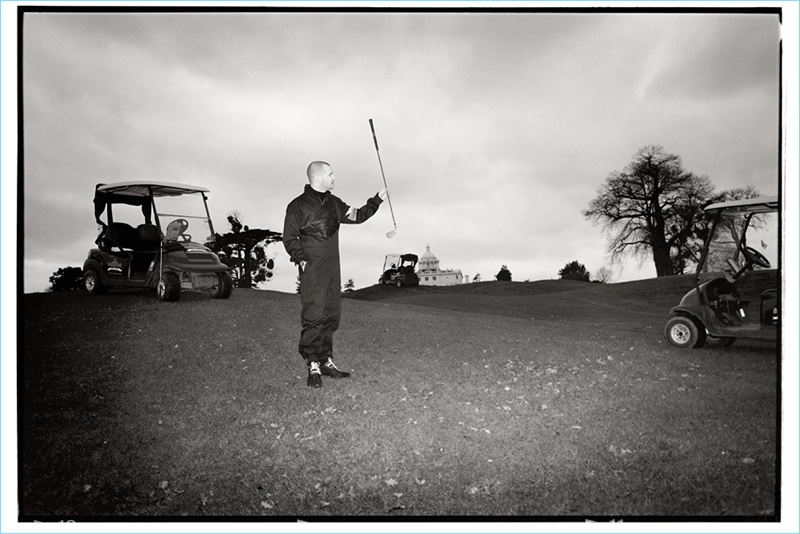 Ready to play golf, Mike Skinner wears a Prada boiler suit with a Calvin Klein turtleneck sweater.