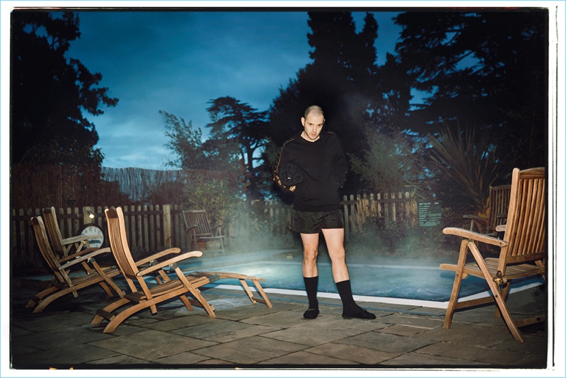 Taking it easy, Mike Skinner wears a Fendi hoodie, Dolce & Gabbana swim shorts, and Tom Ford slides.