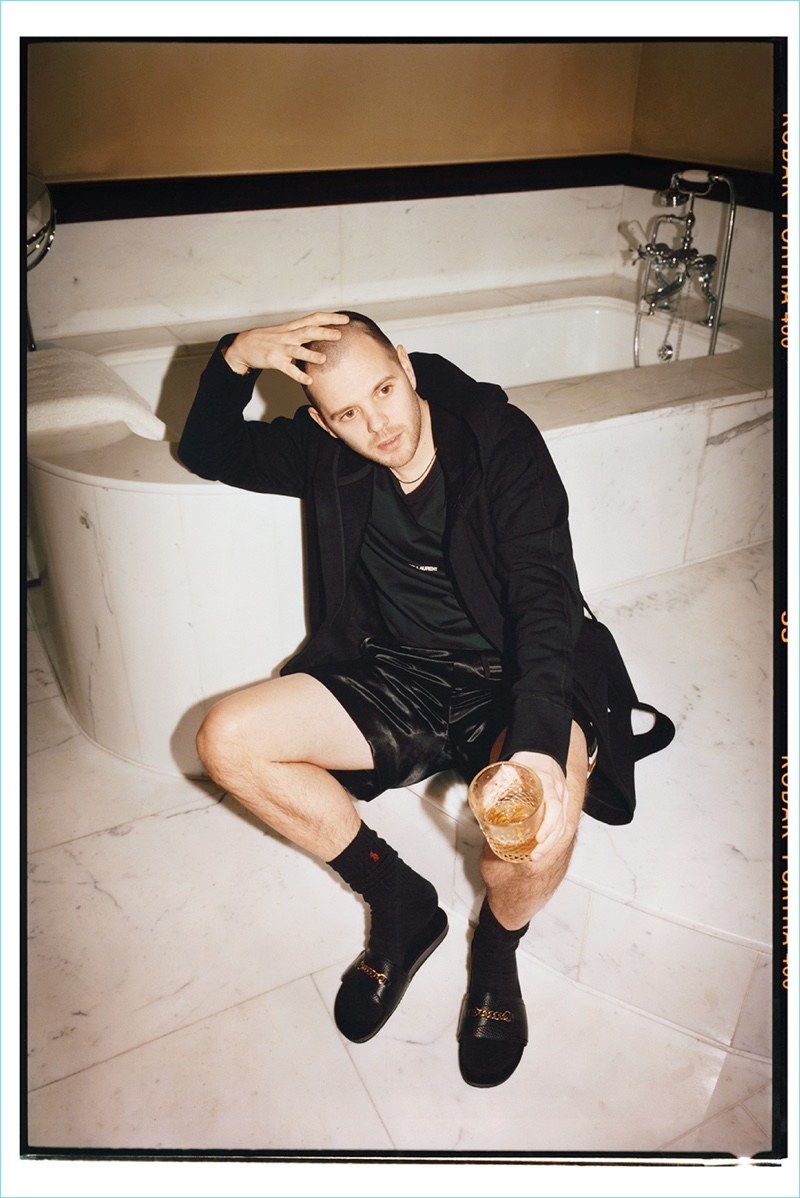 Retreating indoors, Mike Skinner rocks a Reigning Champ hooded robe, Saint Laurent t-shirt, Gucci satin shorts, and Tom Ford leather slides.