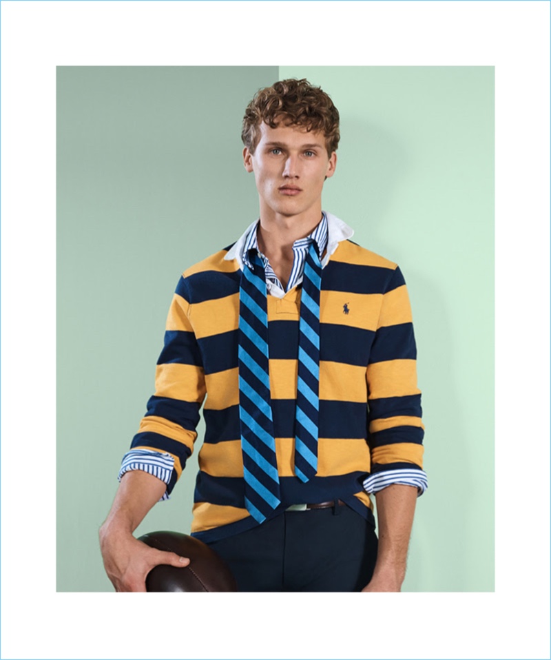 Tapping into rugby style, Bram Valbracht wears POLO Ralph Lauren. The Dutch model sports a striped rugby shirt. He also wears a POLO tie, striped shirt, and chinos.