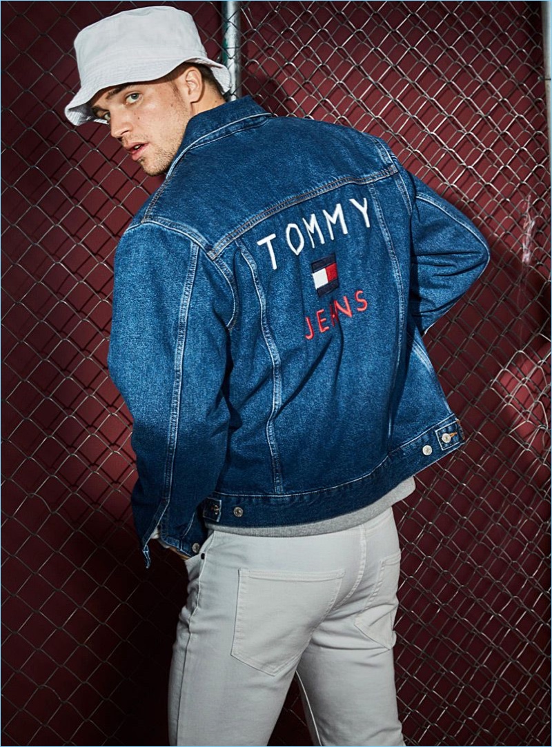 Connecting with Simons, River Viiperi wears a Tommy Jeans denim jacket and LE 31 white jeans. An Adidas Originals bucket hat completes his look.