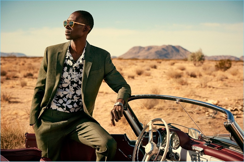 Armando Cabral models Todd Snyder's Sutton linen suit in olive. He also wears a camp collar floral print shirt.