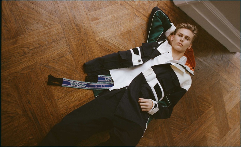 Oliver Houlby wears a Valentino parka, cotton-poplin shirt, logo-print chinos, and a multicolored logo-intarsia belt.