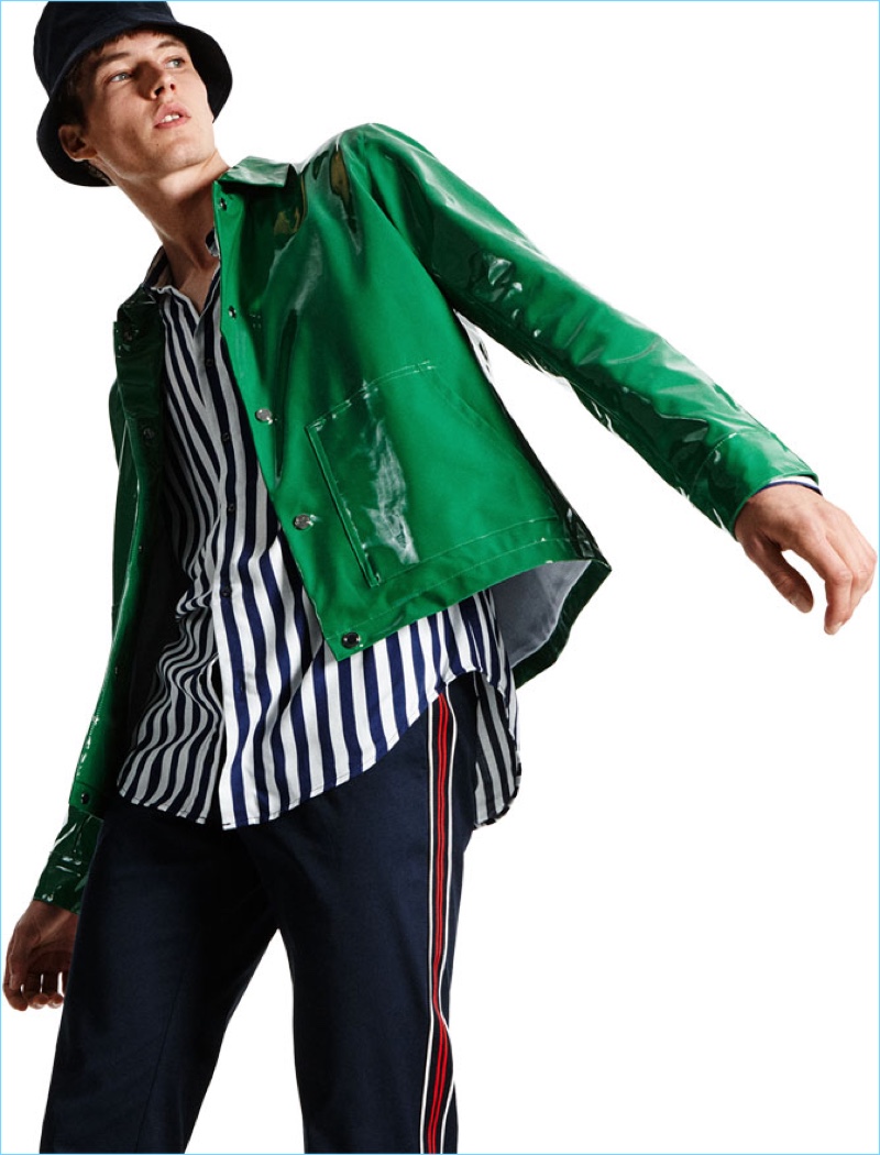 Ready to turn heads, Frederik Ruegger wears a shiny green jacket from Zara Man. It's paired with a Zara striped shirt, trousers with a side stripe, and a bucket hat.