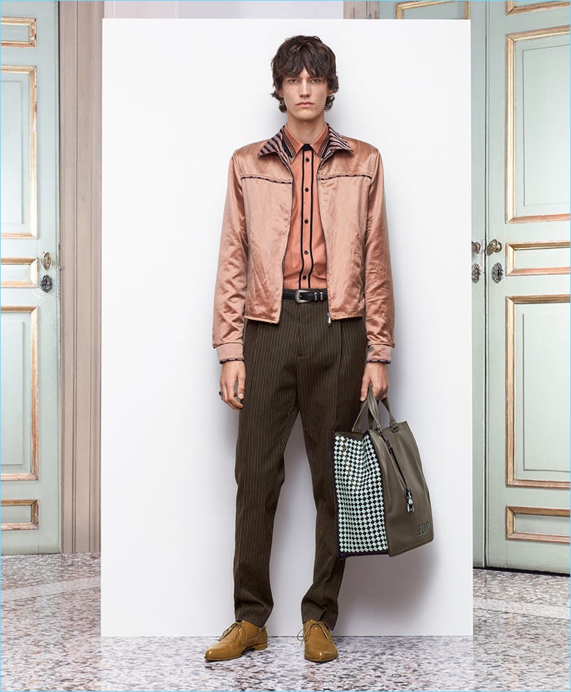 Elias de Poot models a soft patina bomber in antique satin from Bottega Veneta. He also wears the brand's pinstripe trousers.