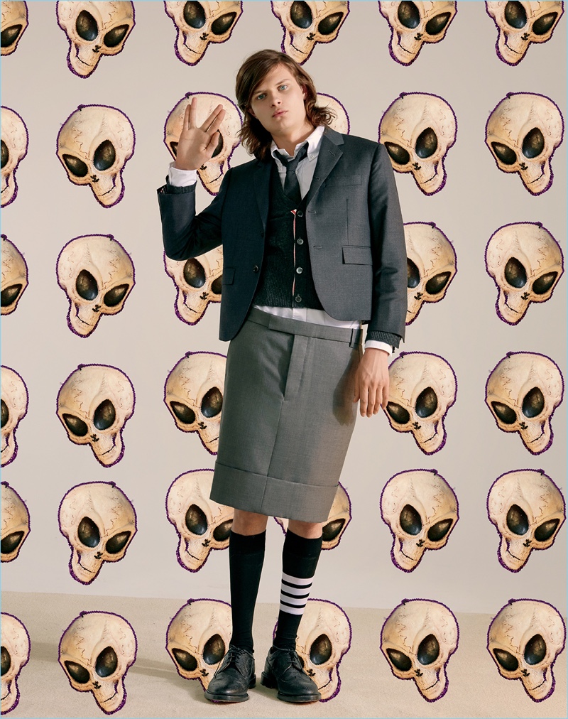 Showcasing a modern preppy side, Charlie Tahan wears Thom Browne. He dons a three-button sport coat, wool cardigan, skirt, and wingtip bluchers. 