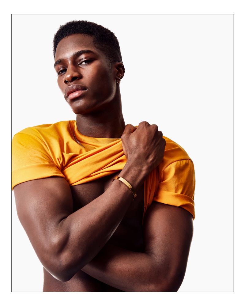 Embracing a pop of color, James Kakonge wears a yellow Topman t-shirt.
