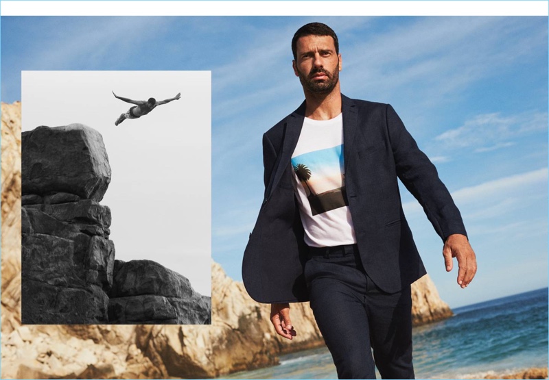 A sleek summer vision, Hugo Parisi wears a linen suit jacket and trousers in navy. He also wears a H&M graphic tee.