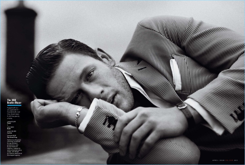 Posing for a black and white photo, James Norton wears a Fendi jacket, Budd shirt, and Cartier watch. A bracelet from The Great Frog completes Norton's look.