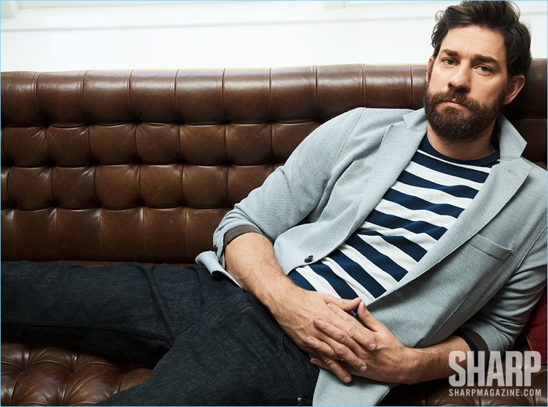 Lounging, John Krasinski wears an Eleventy jersey blazer, striped Rag & Bone t-shirt, and Ermenegildo Zegna pants.