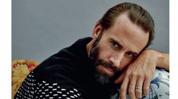 Starring in a photo shoot, Joseph Fiennes wears a Hermès sweater with BOSS pants.
