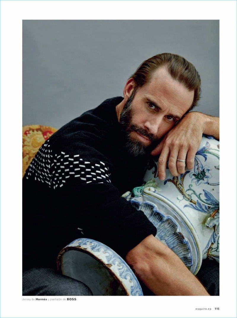 Starring in a photo shoot, Joseph Fiennes wears a Hermès sweater with BOSS pants.