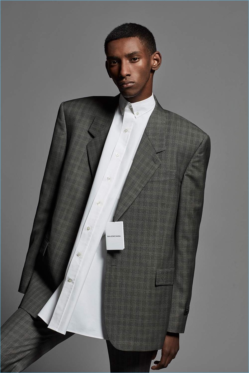 Embracing boxy suiting, Myles Dominique dons a Balenciaga Prince of Wales checked wool and mohair-blend suit with a button-down shirt.