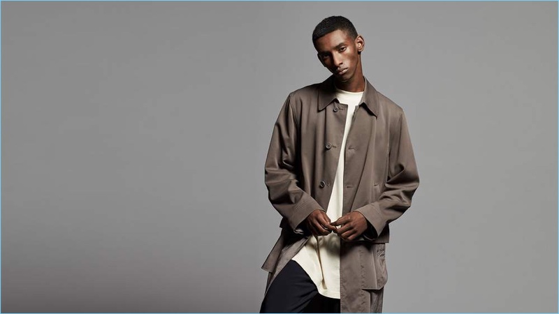Myles Dominique wears a Dries Van Noten trench coat with an oversized Rick Owens DRKSHDW jersey t-shirt.