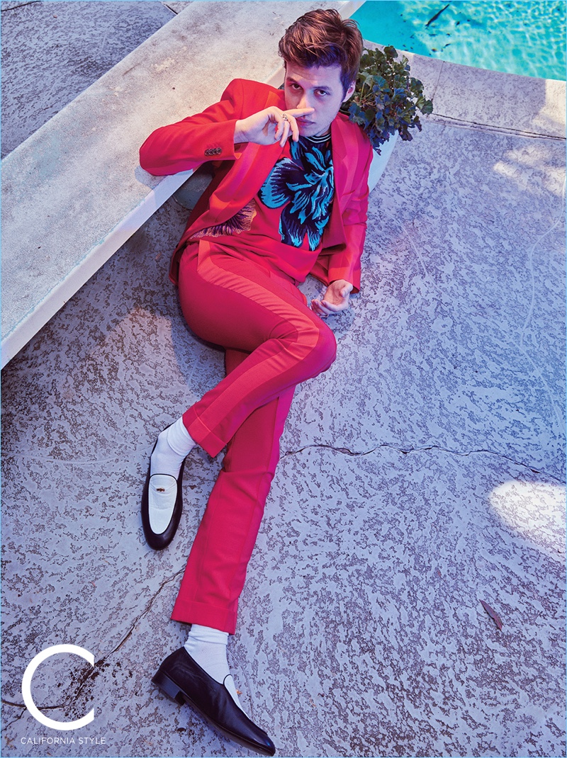 Relaxing poolside, Nick Robinson wears a Paul Smith suit and sweater with Giuseppe Zanotti loafers.