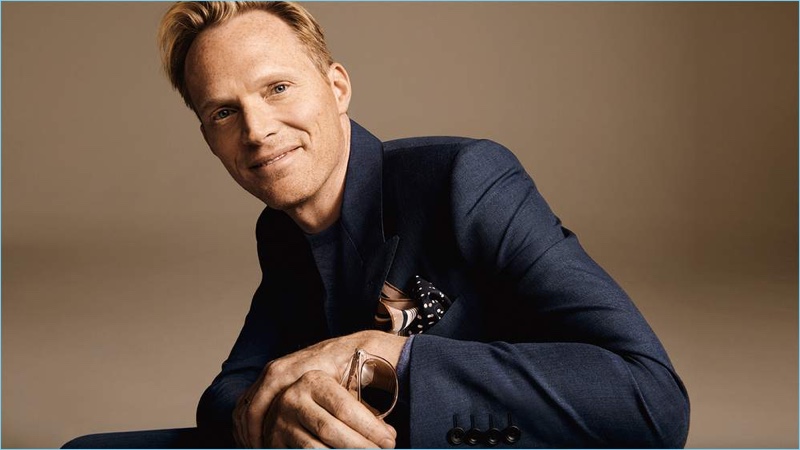 Paul Bettany wears a Kingsman sweater and double-breasted suit jacket. He accessorizes with Saint Laurent sunglasses and a Dries Van Noten printed silk pocket square.