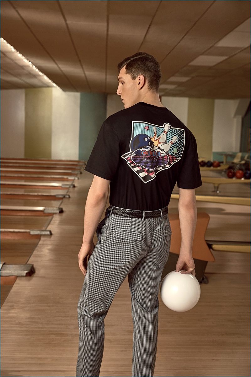 Going bowling, Luke Farley sports a Prada graphic tee and trousers.