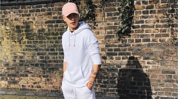 Iago Faria rocks a cap, hoodie, and sweat shorts from River Island's Concept collection.