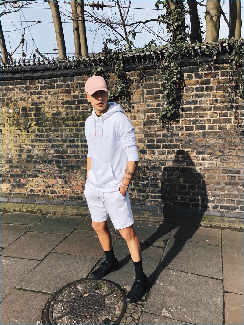 Iago Faria rocks a cap, hoodie, and sweat shorts from River Island's Concept collection.