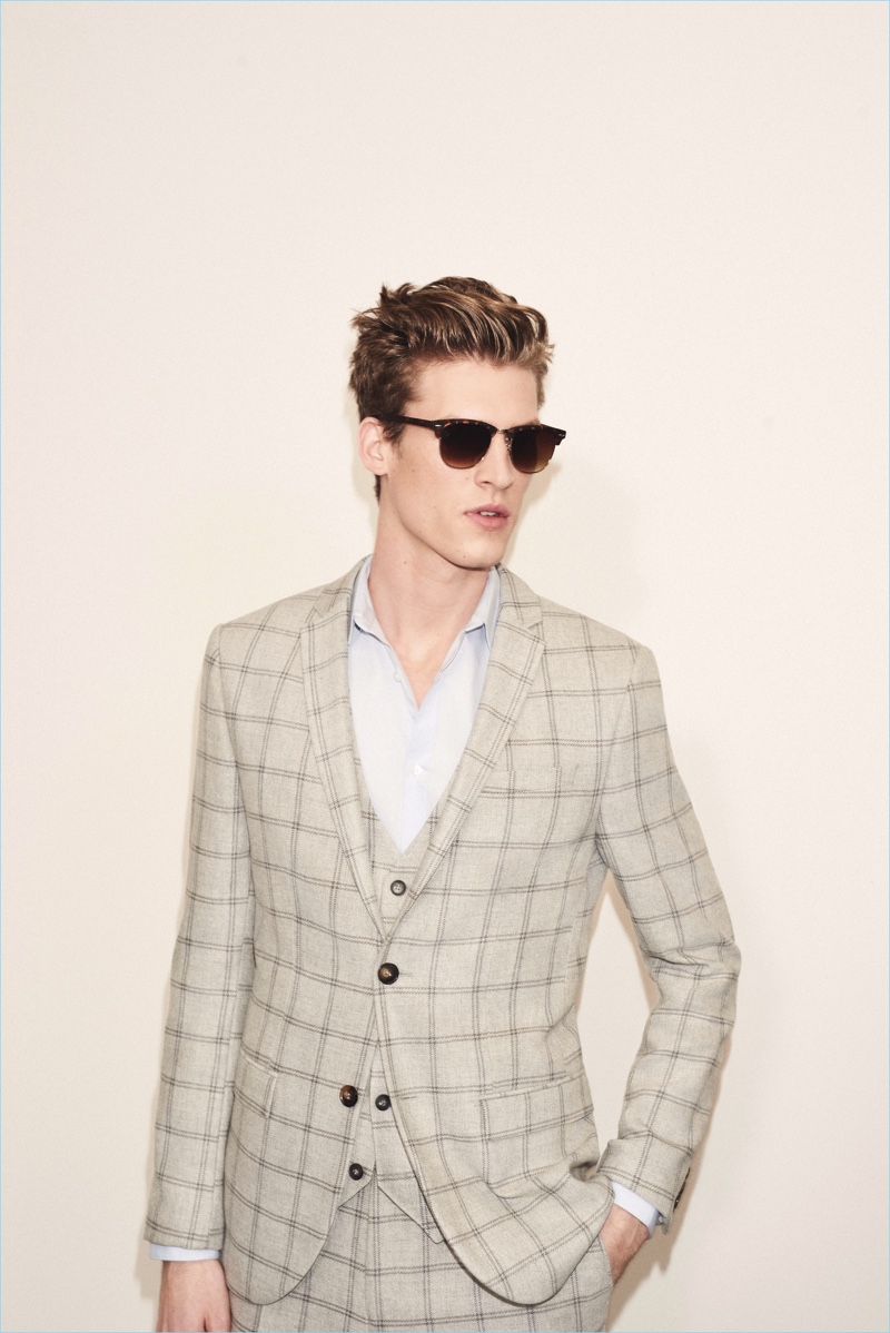 Reuniting with River Island, Joel Meacock is a sleek vision in a windowpane print suit.