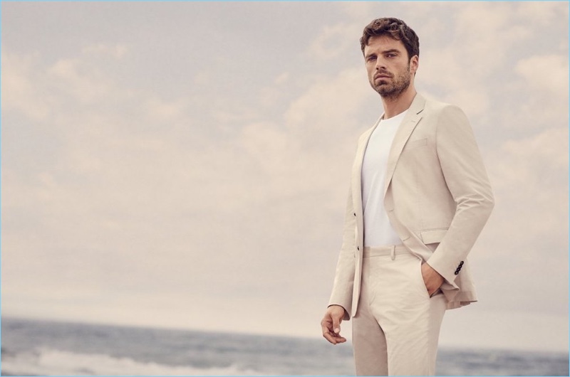 Donning a neutral suit, Sebastian Stan takes to the beach for BOSS' "Summer of Ease" campaign.