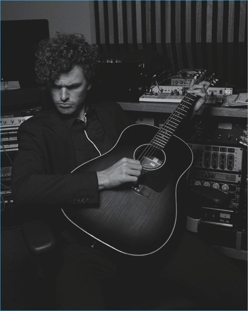 Playing the guitar, Vance Joy wears Emporio Armani.