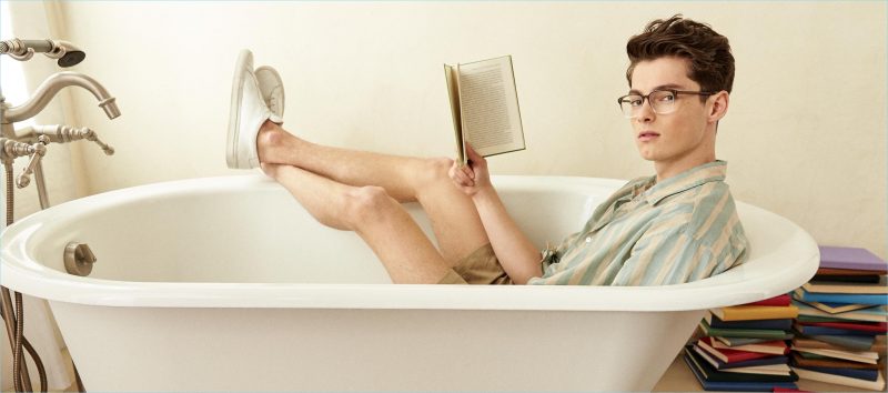 Reading a book, Quinn wears Warby Parker's Dawes glasses in Driftwood Fade.