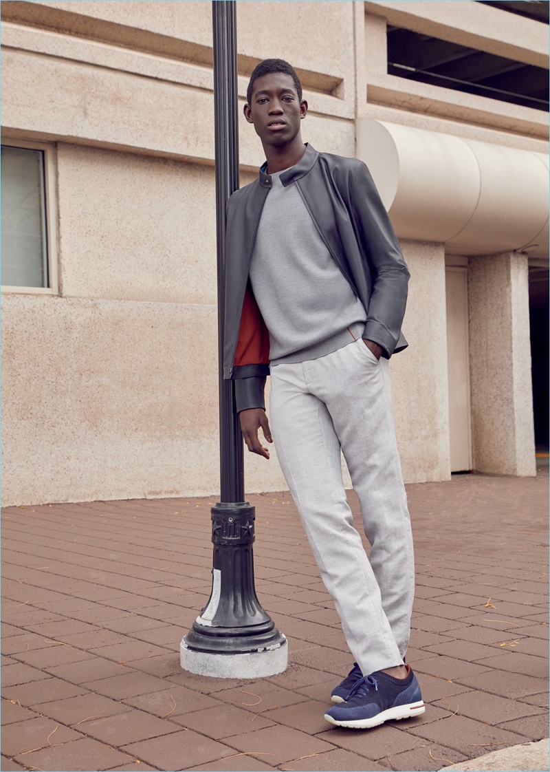 Erwan wears a Loro Piana bomber jacket, drawstring trousers, sweater, and sneakers. 