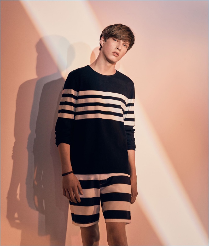 Embracing stripes, Gideon Yendell sports a Club Monaco pullover and swim trunks.