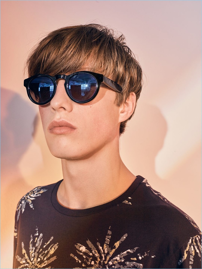 Model Gideon Yendell wears Illesteva sunglasses with a burst print tee by Club Monaco.