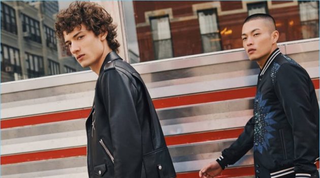Left to Right: Serge Rigvava wears a Coach 1941 moto jacket in black. Satoshi Toda models a Coach 1941 patchwork varsity jacket. Both models carry Coach's Metropolitan Portfolio leather bag.