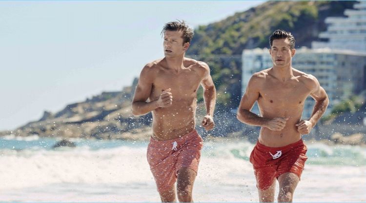 Models George Paul and Greg Kheel hit the beach in swim shorts from Derek Rose's resort 2018 collection.