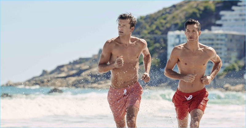 Models George Paul and Greg Kheel hit the beach in swim shorts from Derek Rose's resort 2018 collection.