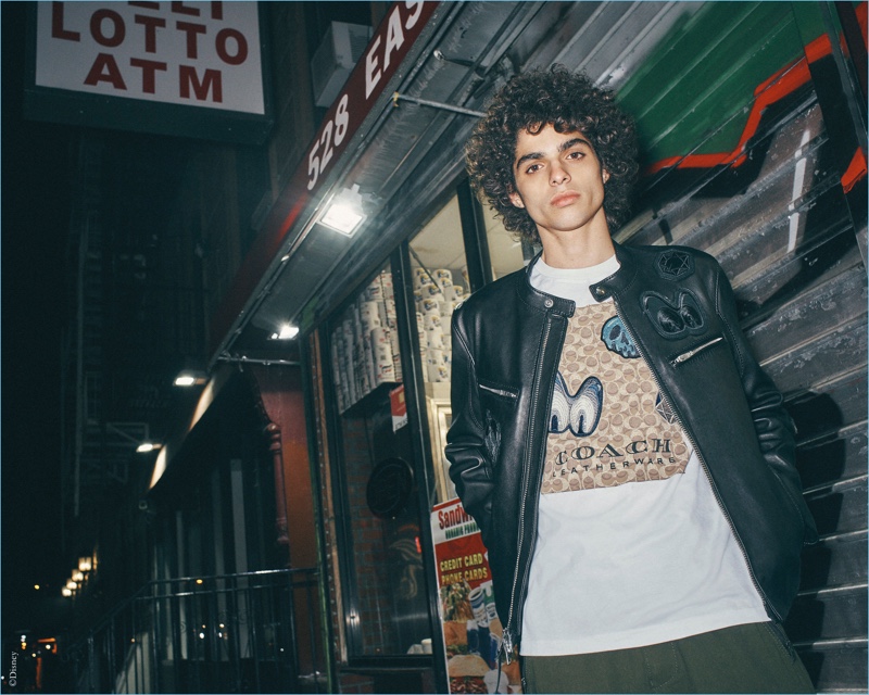 Kobe Delgado wears a leather jacket and graphic tee from the Disney x Coach "A Dark Fairy Tale" collection.