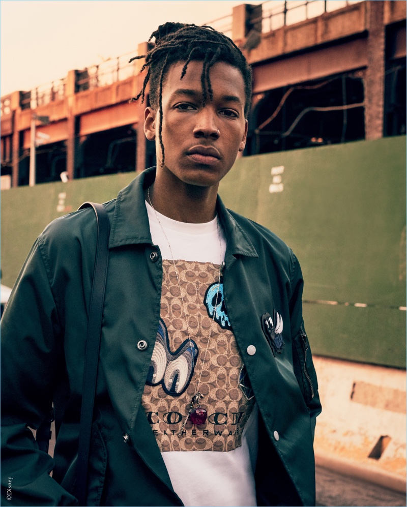 Matthew Davidson sports a coach's jacket and graphic tee from the Disney x Coach "A Dark Fairy Tale" collection. » A Dark Fairy Tale: Coach Collaborates with Disney Matthew Davidson sports a coach's jacket and graphic tee from the Disney x Coach "A Dark Fairy Tale" collection.