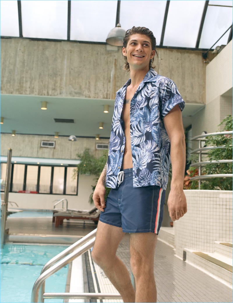 All smiles, Jake Lahrman wears a Naked & Famous tropical leaves print shirt with SUNDEK classic board shorts.